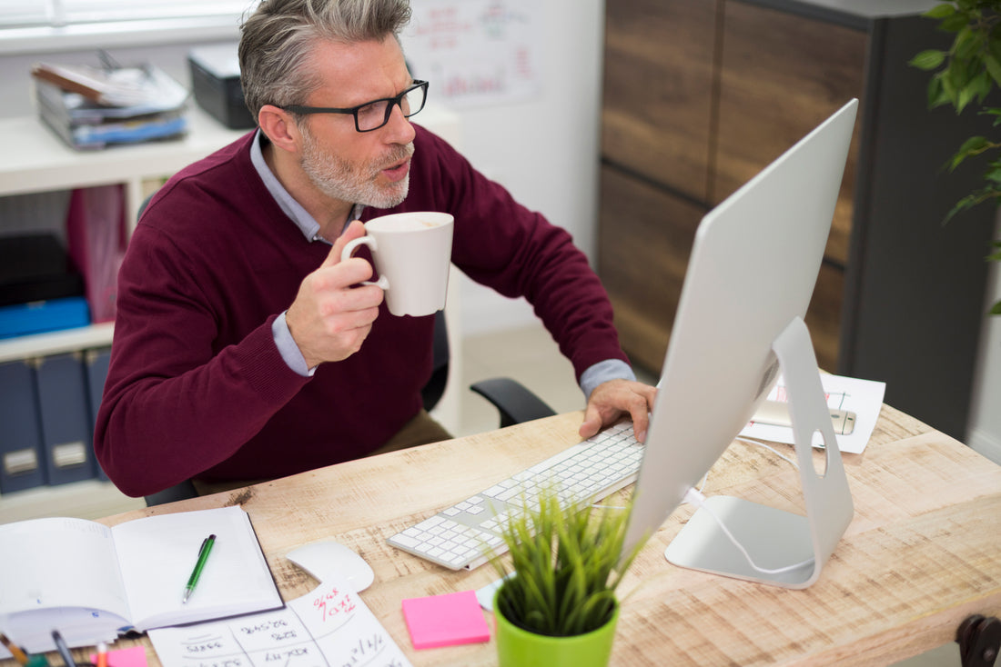 A confident Middle-Eastern CISO stands at the forefront of a vibrant conference room, engaging with a diverse group of professionals. Behind him, a digitized gl